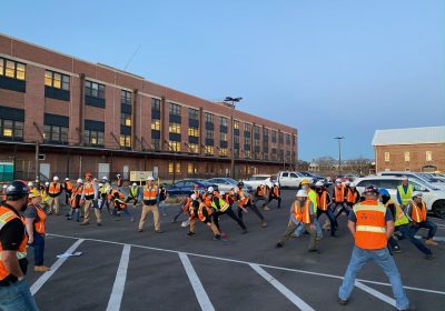 A Group Of People Standing In A Parking Lot